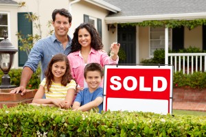 family-in-front-of-sold-sign
